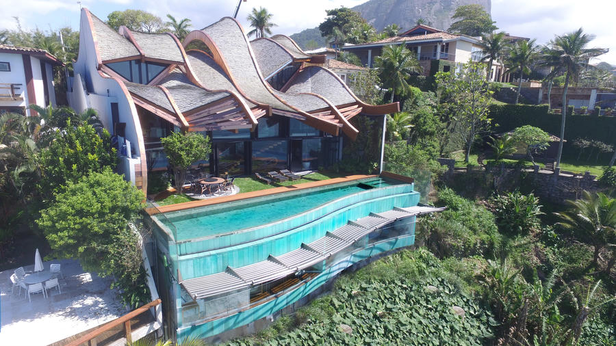  Ngoài ra phía trong của công trình là khu vực hồ bơi ngoài trời hướng về khu vườn nhỏ xanh mát. Thiết kế hồ bơi cũng có độ nghiêng và uốn lượn giống như một con sóng nhỏ.